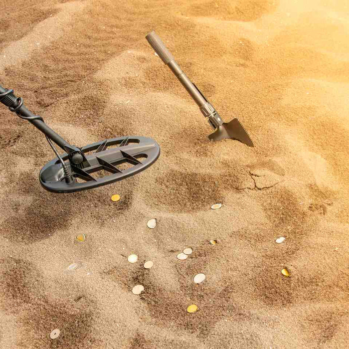 metal detector and a shovel on sand