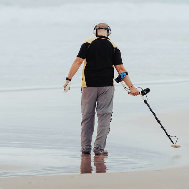 metal detectorist on a beach